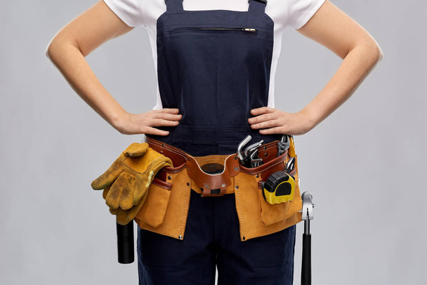 woman or builder with working tools on belt - Фото, зображення