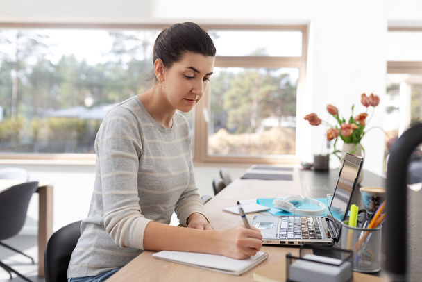 young woman with laptop working at home office - Foto, imagen