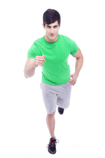 Athletic young man running, isolated over a white background - Fotoğraf, Görsel