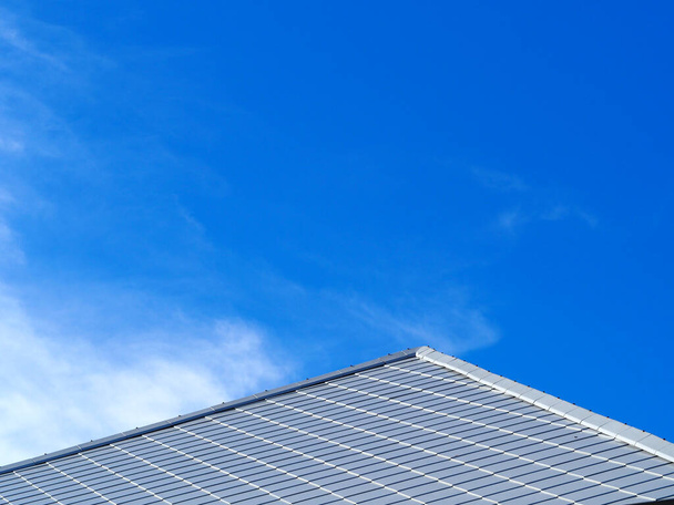 Laatta katto ja kaltevuus pilvet ja sininen taivas tausta.Laatta katto rakentamisen talon sininen taivas ja pilvi tausta. - Valokuva, kuva