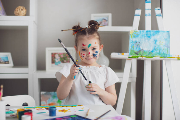 Κόψτε το κορίτσι ζωγραφική στο σπίτι της. Επιλεκτική εστίαση  - Φωτογραφία, εικόνα