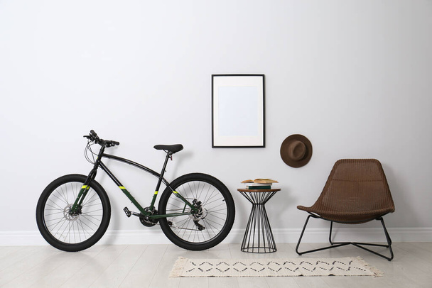 Modern bicycle and comfortable armchair in stylish living room interior - Foto, Imagen