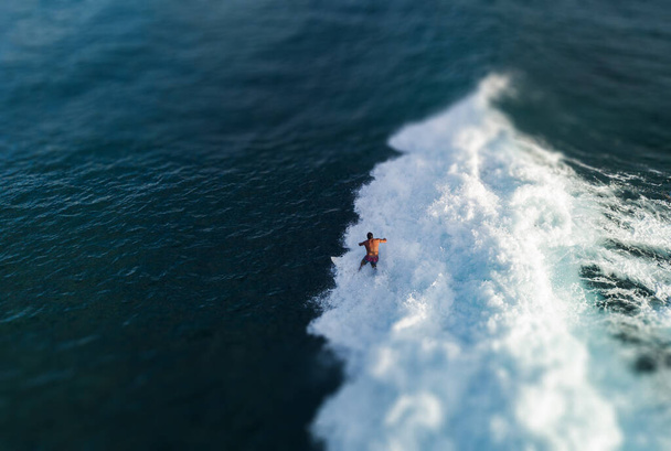 Aerial view of the surfer riding the ocean wave. Oahu, Hawaii. Tilt shift effect applied - Foto, imagen