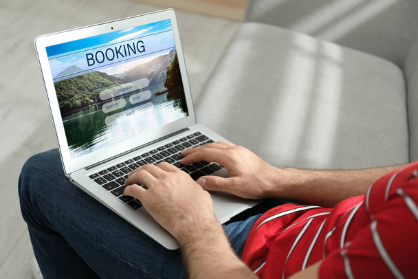 Man using laptop to plan trip, closeup. Travel agency website - Фото, изображение