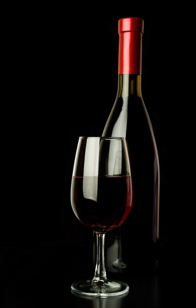 red wine glass and a wine bottle over black - Foto, Imagen