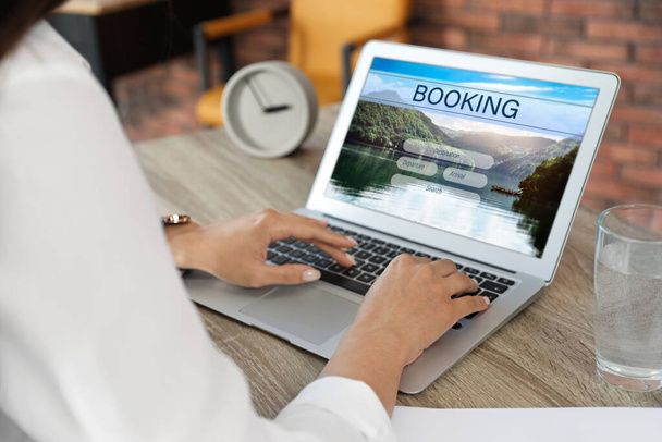 Woman using laptop to plan trip, closeup. Travel agency website - Zdjęcie, obraz