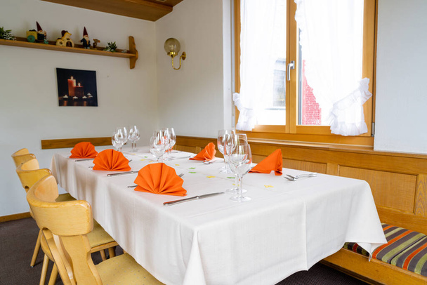 Ένα γοητευτικό και ζεστό τραπέζι και τοποθετήστε τις ρυθμίσεις εσωτερικό πλάνο ενός τραπεζιού εστιατόριο - Φωτογραφία, εικόνα