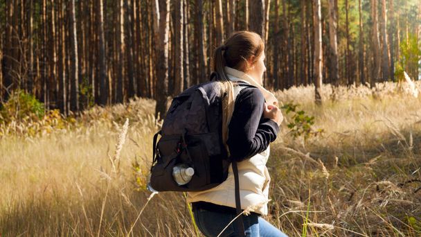 Gyönyörű fiatal női turista sétál egyedül fenyőerdőben - Fotó, kép