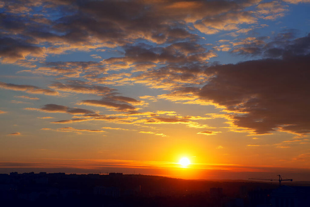 majestatyczny zegar słoneczny wieczorem, sylwetka dźwigu budowlanego na tle zachodzącego słońca - Zdjęcie, obraz