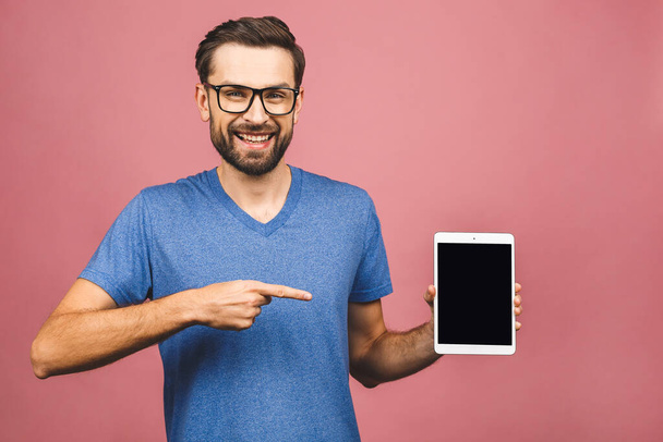 Présentation du produit. Promotion. Jeune homme tenant dans les mains tablette ordinateur avec écran blanc, fermer. Isolé sur fond rose
.  - Photo, image