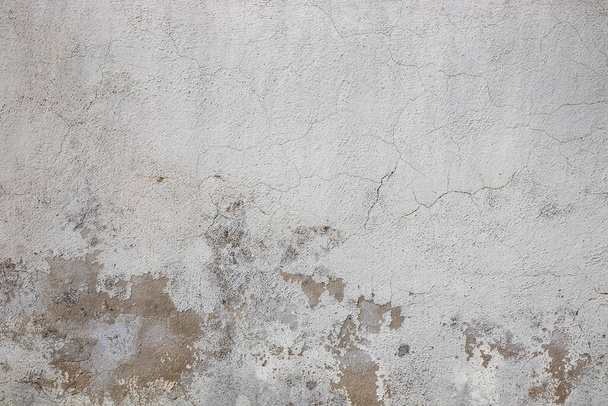 Gray wall ruined by time, bad weather and humidity. Cracks, mold, peeling paint and plaster. Texture, material background. - Фото, зображення