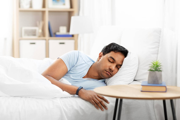 indian man with tracker sleeping in bed at home - Valokuva, kuva