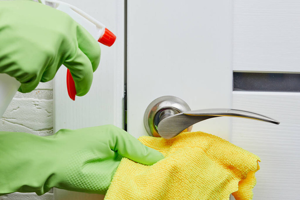 Female hands disinfect and wash of door handles. Prevention of coronavirus infection during the COVID-19. White door. - Valokuva, kuva