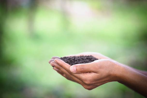 Soil in farmers hand green background. - Photo, Image