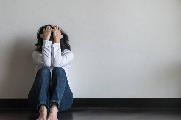Paniikkikohtaus nainen, stressaavaa masentunut emotionaalinen henkilö ahdistuneisuushäiriö mielenterveyden sairaus, päänsärky ja migreeni istuu huono selkä seinää vasten lattialla kotimaassa - Valokuva, kuva