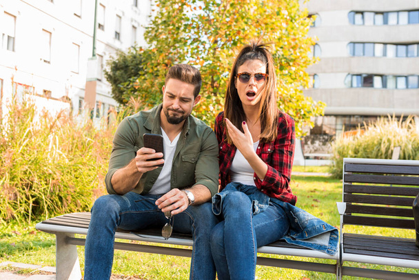 A couple being shocked over content seen on the screen of a phone - Foto, Imagen