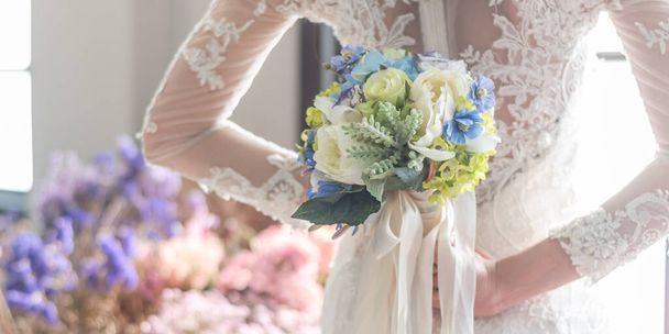 Νύφη σε λευκό νυφικό κρατώντας μπουκέτο λουλουδιών για κομψή γαμήλια τελετή έννοια - Φωτογραφία, εικόνα