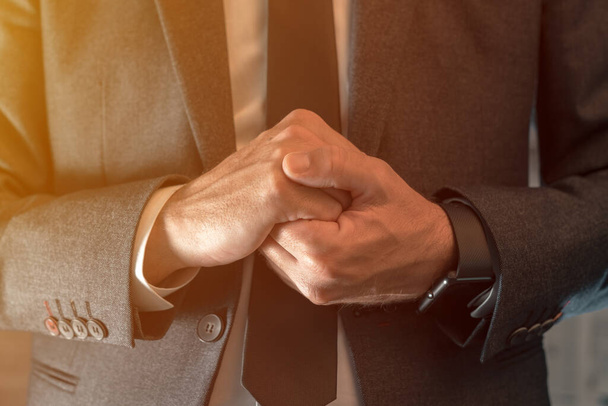 Nervous businessman clenching hands, close up with selective focus - Foto, Bild