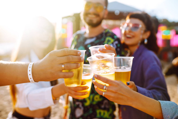 Group of friends with beer dancing and having fun at music festival together. Summer Beach party, holiday, vacation concept.Youth and celebration concept. - Fotoğraf, Görsel