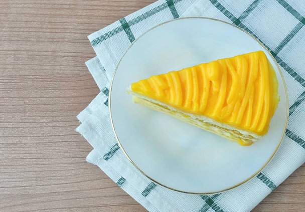 Snack und Dessert, Ein Stück Mangokuchen mit Butter, Eiern, Zucker, Mehl, Backpulver und Aromen, garniert mit Mangosoße. - Foto, Bild