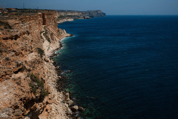 Bela vista do penhasco no mar azul. Uma costa incrível com falésias independentes no mar. Cabo Fiolent, Crimeia
. - Foto, Imagem