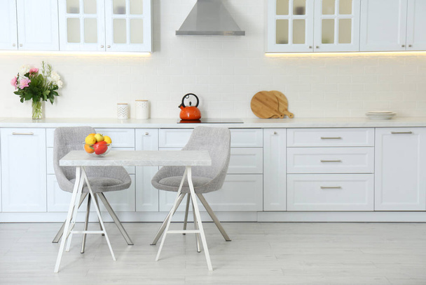 Table with chairs in modern kitchen interior - Foto, afbeelding