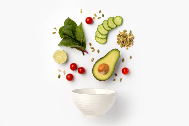 Composition créative avec ingrédients de salade et bol en céramique
 - Photo, image
