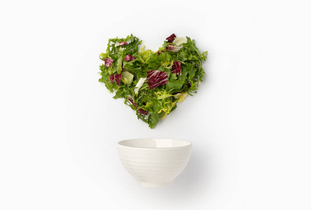 Creative composition with lettuce in heart shape and ceramic bowl - Photo, Image