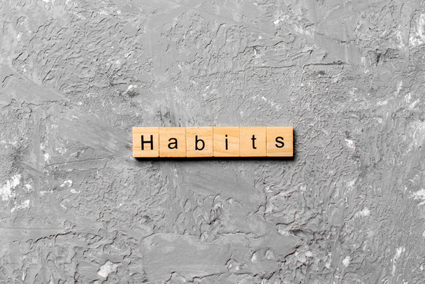 HABITS word written on wood block. HABITS text on cement table for your desing, concept. - Photo, Image