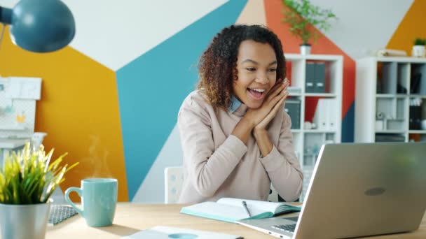 Бесконечный цикл счастливой афро-американской бизнес-леди, смотрящей на экран ноутбука и выражающей счастье
 - Кадры, видео