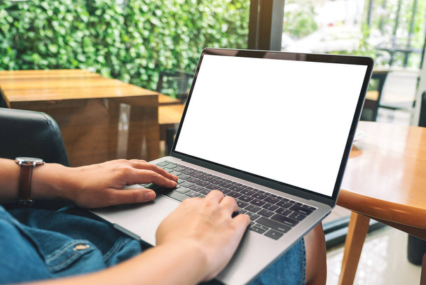 Mockup obrazu kobiety za pomocą i wpisując na klawiaturze laptopa z pustym białym ekranem pulpitu  - Zdjęcie, obraz