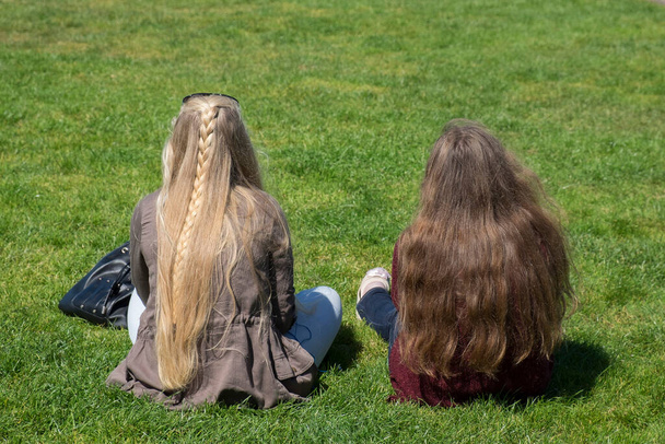 Δύο έφηβοι χαλαρώνουν στο γρασίδι στο πάρκο - Φωτογραφία, εικόνα