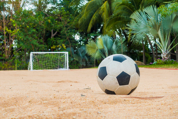 Футбольний м'яч на піщаному пляжі з невеликою метою на задньому плані
 - Фото, зображення