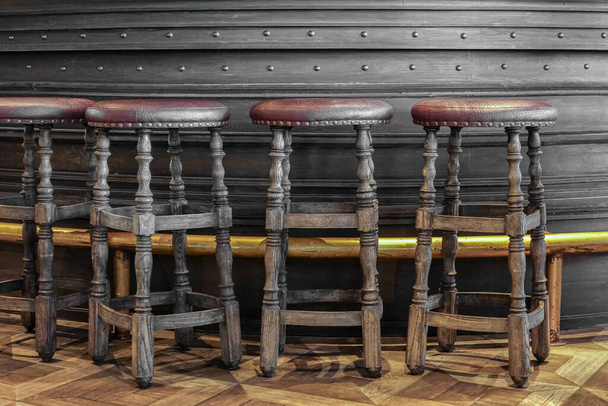 Sillas altas rústicas de madera en el mostrador del bar. Con cubierta superior de cuero
 - Foto, imagen