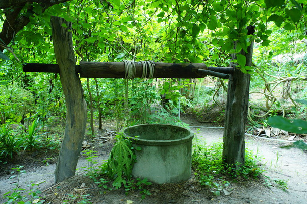 Drewniane kłody z liną na szczycie studni do podziemnej wody - Zdjęcie, obraz