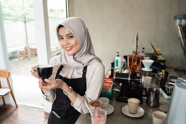 asian veiled waitress smiling hold a cup of coffee - Photo, Image