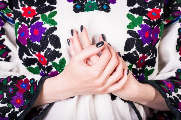 Woman in an old Ukrainian embroidered shirt, fragment. Manicure with black nail polish - Фото, изображение