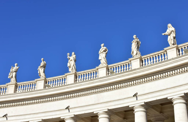 Berninis Colonnade and statues at St. Peters Square with blue sky. Vatican City, Rome, Italy. - Fotó, kép