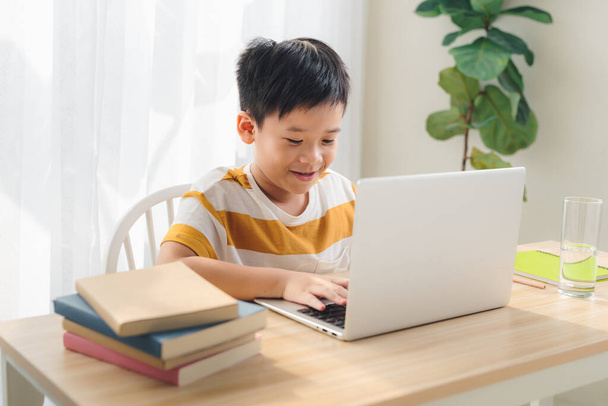 Afbeelding van een scholier die thuis studeert met een laptop geïsoleerd - Foto, afbeelding