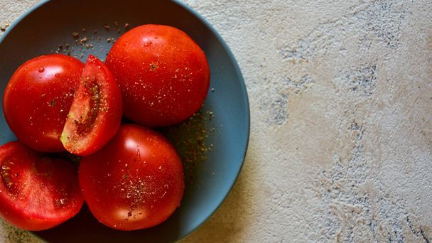 Plate with ripe tomatoes sprinkled with provencal herbs. Top view. Summer background. - Photo, Image