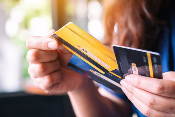 Imagen de primer plano de una mujer sosteniendo y eligiendo la tarjeta de crédito para usar
 - Foto, imagen