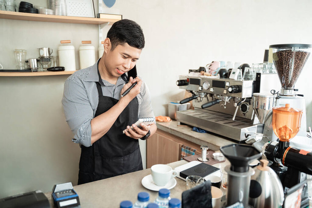 male barista calling using smartphone - Foto, Bild