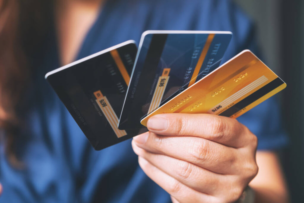 Κλείσιμο εικόνας μιας γυναίκας που κατέχει και δείχνει πιστωτικές κάρτες - Φωτογραφία, εικόνα