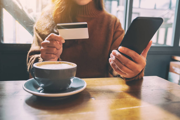 Une femme utilisant une carte de crédit pour acheter et faire des achats en ligne sur un téléphone mobile
 - Photo, image
