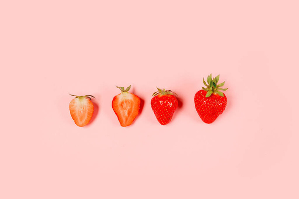 Вид зверху органічні смачні полуничні ягоди з копіспасом на рожевому фоні, мінімальна композиція
 - Фото, зображення