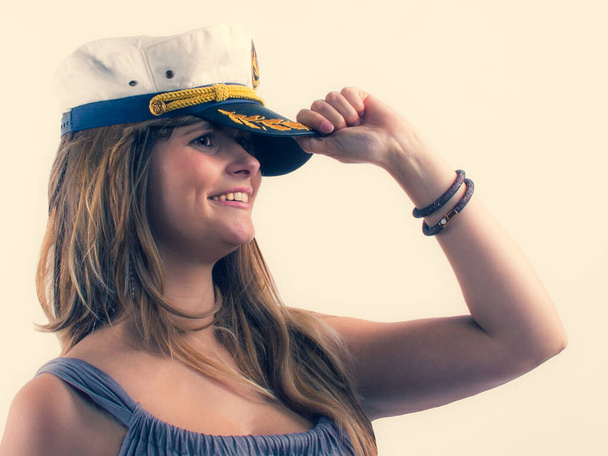 Retrato de una alegre chica sonriente sosteniendo su gorra de mar, itinerario de viaje marítimo de verano
. - Foto, imagen
