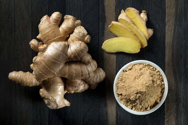 Ground ginger root in a bowl on a wooden table. - Photo, Image
