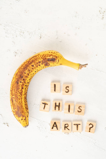 uma banana madura em um fundo branco texturizado com espaço de cópia
 - Foto, Imagem