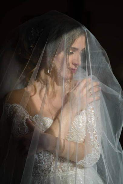 Egy gyönyörű menyasszony portréja fátyol alatt.. - Fotó, kép