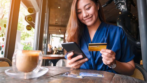 Крупный план с изображением азиатки, использующей кредитную карту для покупок и покупок онлайн на мобильном телефоне
 - Фото, изображение